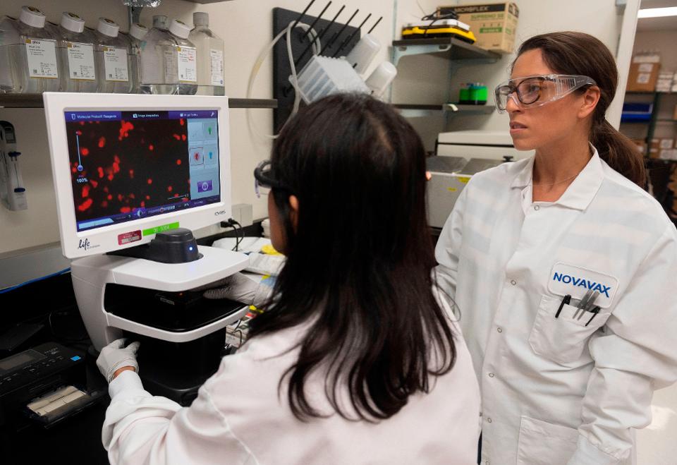 A Dra. Sonia Macieiewski (R) e a Dra. Nita Patel, Diretora de descoberta de anticorpos e desenvolvimento de vacinas, examinam uma amostra de vírus respiratório nos laboratórios da Novavax em Rockville, Maryland, em 20 de março de 2020, um dos laboratórios que desenvolvem uma vacina para o coronavírus, COVID-19.
